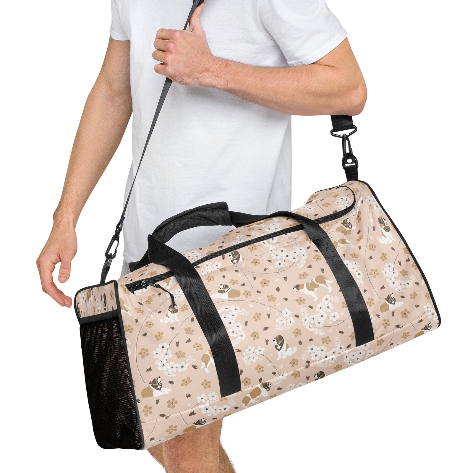 Floral Saint Bernard duffle bag with adjustable padded black shoulder strap, dual carry handles, zippered compartments, and mesh side pocket in white, brown, gold, and soft pink.