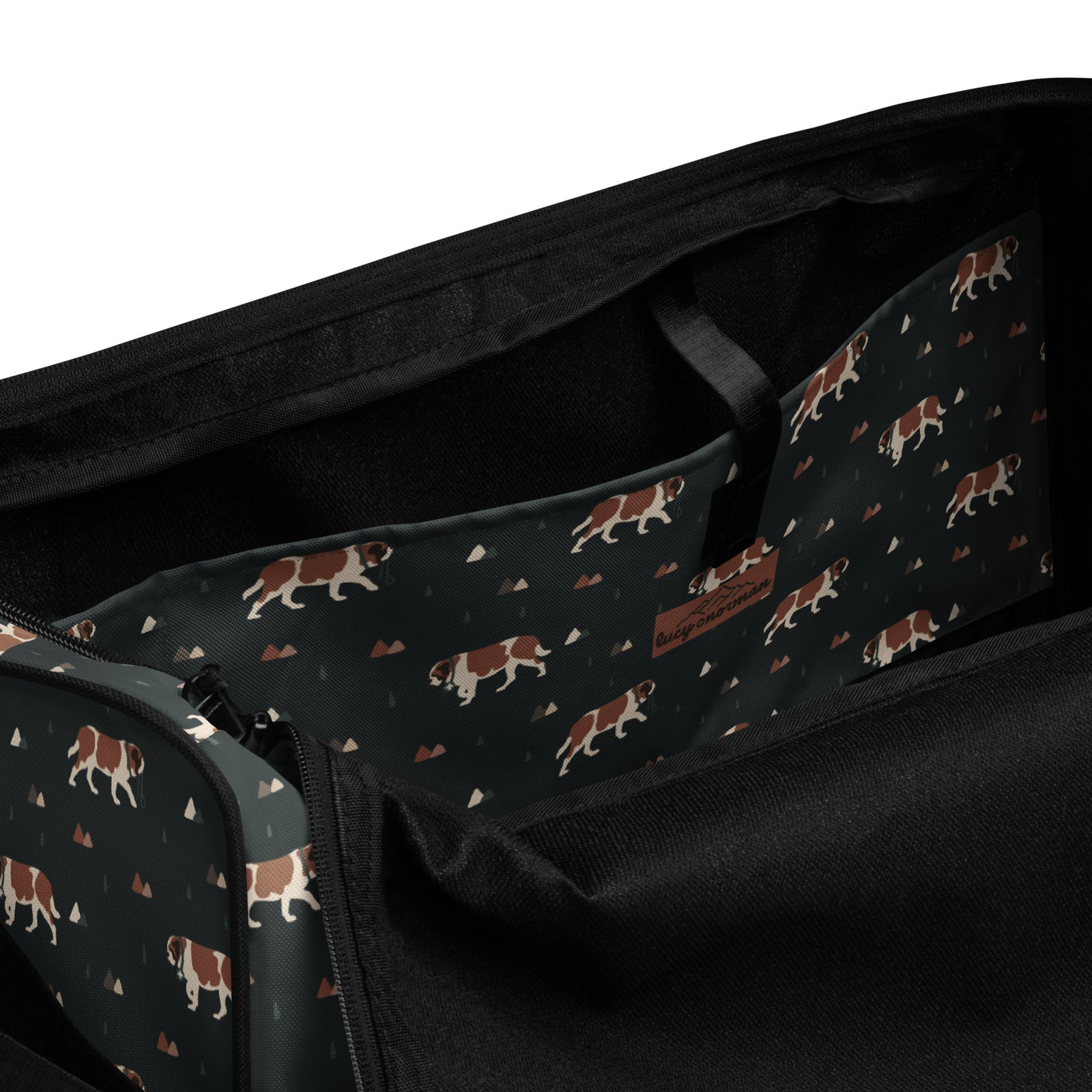 Green Mountain Saint Bernard duffle bag with adjustable padded black shoulder strap, handles, zip compartment, and mesh side pocket on dark green background with mountains, pines and dog pattern.