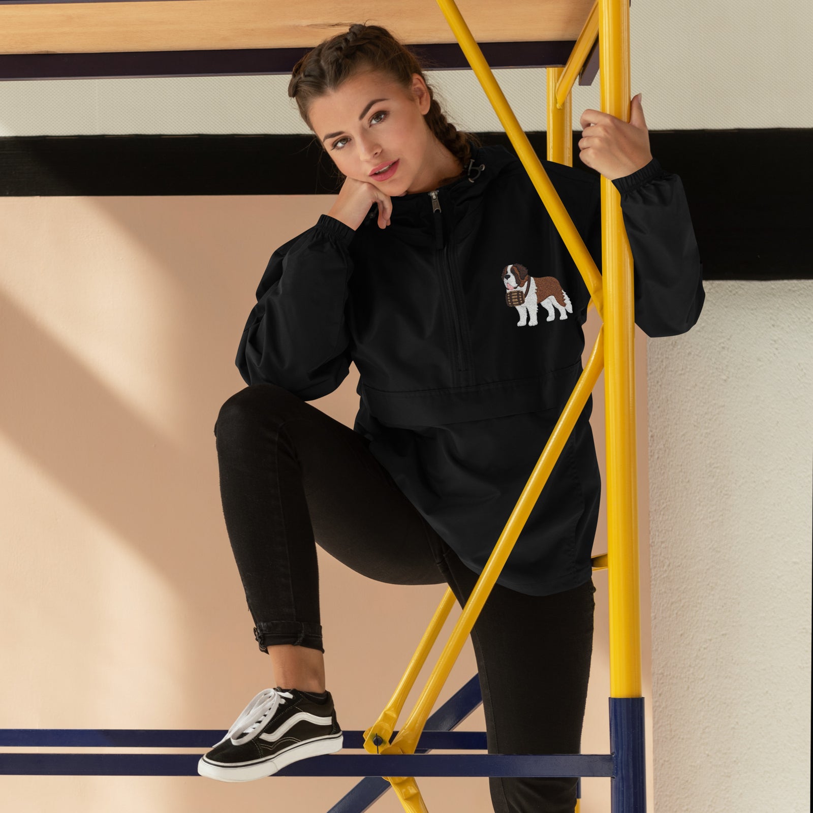 Black Champion packable windbreaker with chest embroidered Saint Bernard and barrel, half zip pullover with hood, kangaroo pocket, and zip pouch.