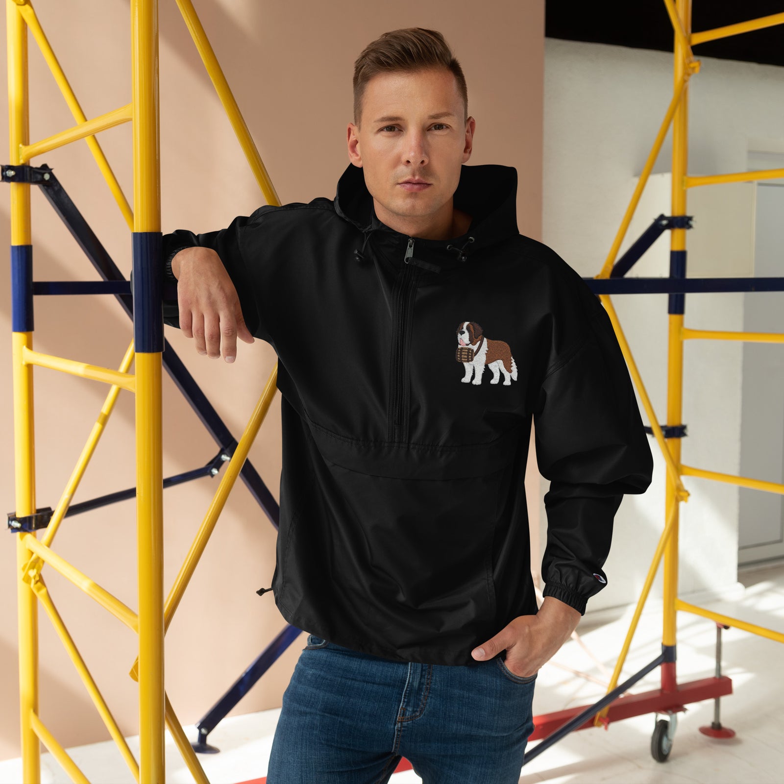 Black Champion packable windbreaker with chest embroidered Saint Bernard and barrel, half zip pullover with hood, kangaroo pocket, and zip pouch.