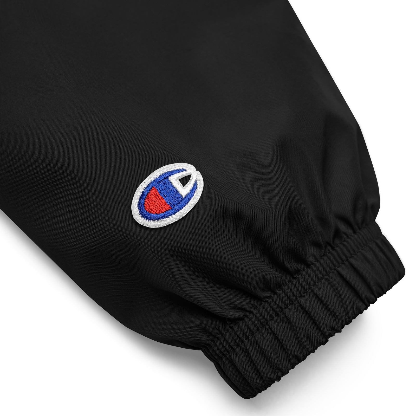 Black Champion packable windbreaker with chest embroidered Saint Bernard and barrel, half zip pullover with hood, kangaroo pocket, and zip pouch.