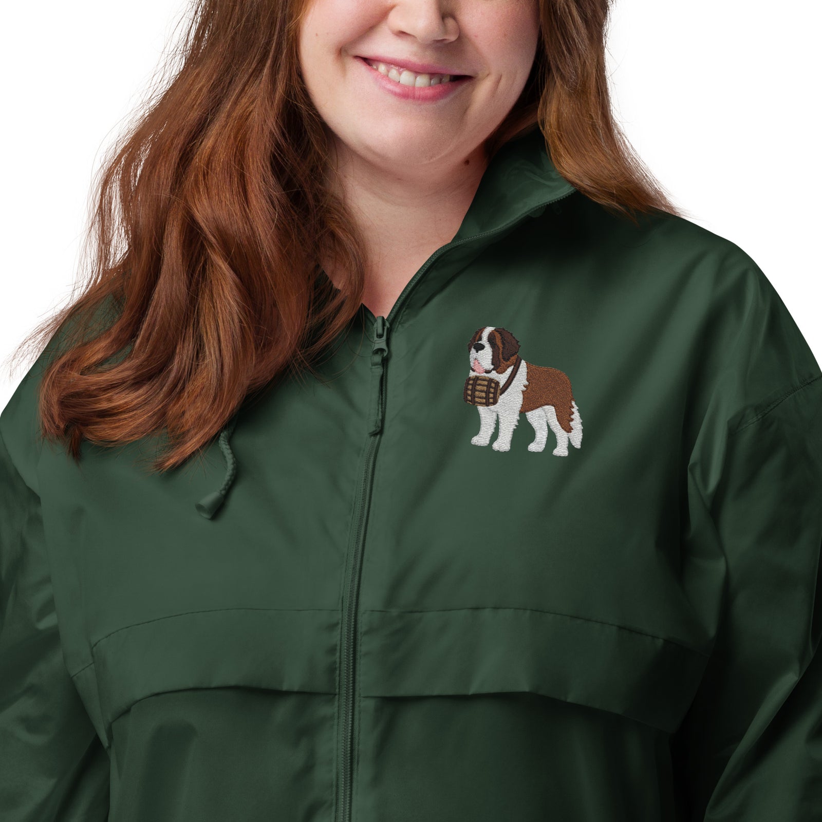 Lightweight, packable forest green windbreaker with chest embroidered Saint Bernard and barrel, adjustable hood, elastic cuffs, and zip pockets.