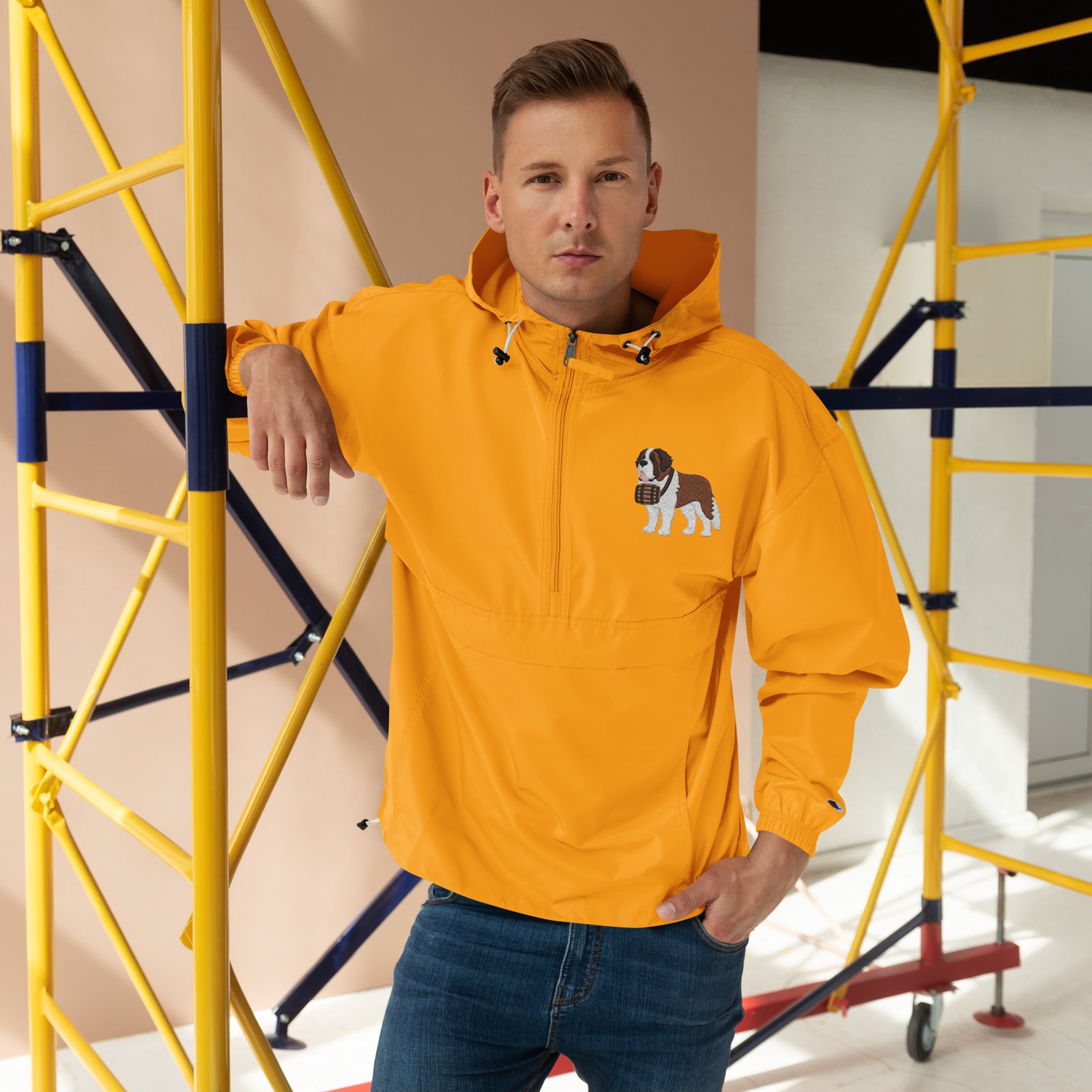 Gold Champion packable windbreaker with chest embroidered Saint Bernard and barrel, half zip pullover with hood, kangaroo pocket, and zip pouch.