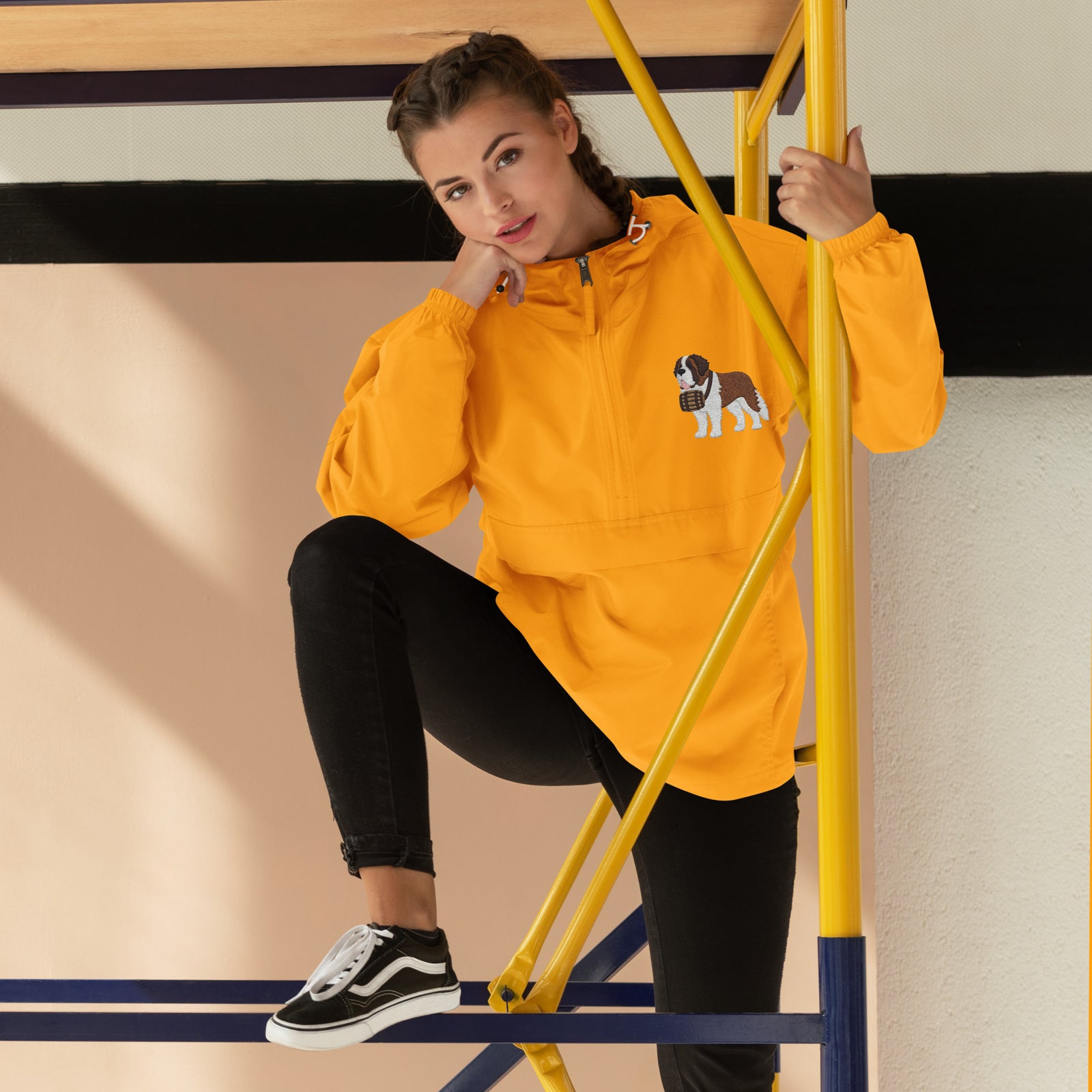Gold Champion packable windbreaker with chest embroidered Saint Bernard and barrel, half zip pullover with hood, kangaroo pocket, and zip pouch.