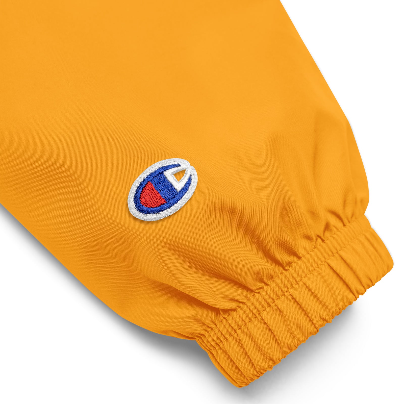 Gold Champion packable windbreaker with chest embroidered Saint Bernard and barrel, half zip pullover with hood, kangaroo pocket, and zip pouch.