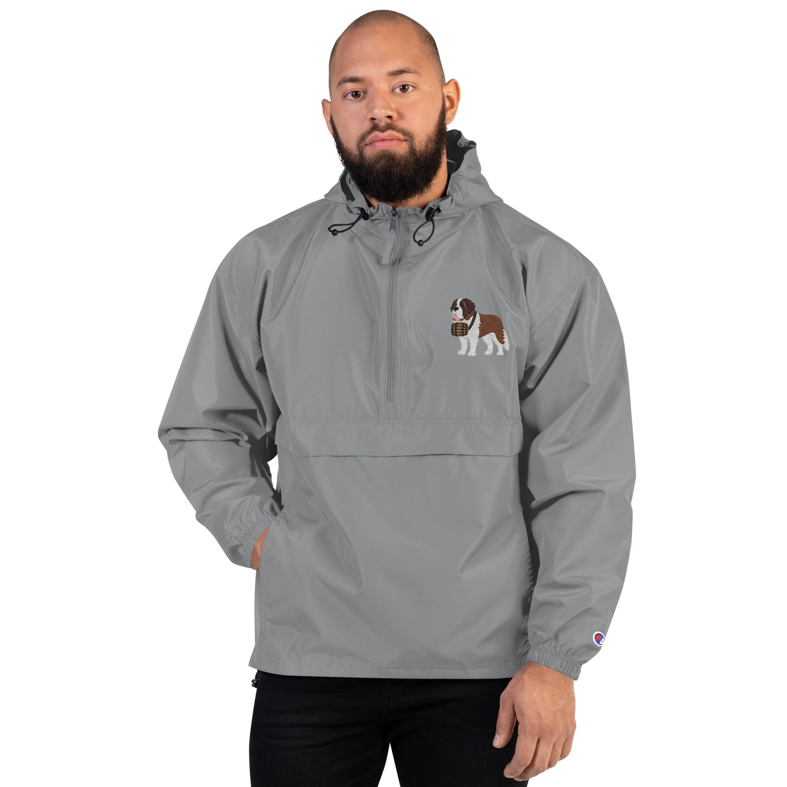Light gray Champion packable windbreaker with chest embroidered Saint Bernard and barrel, half zip pullover with hood, kangaroo pocket, and zip pouch.
