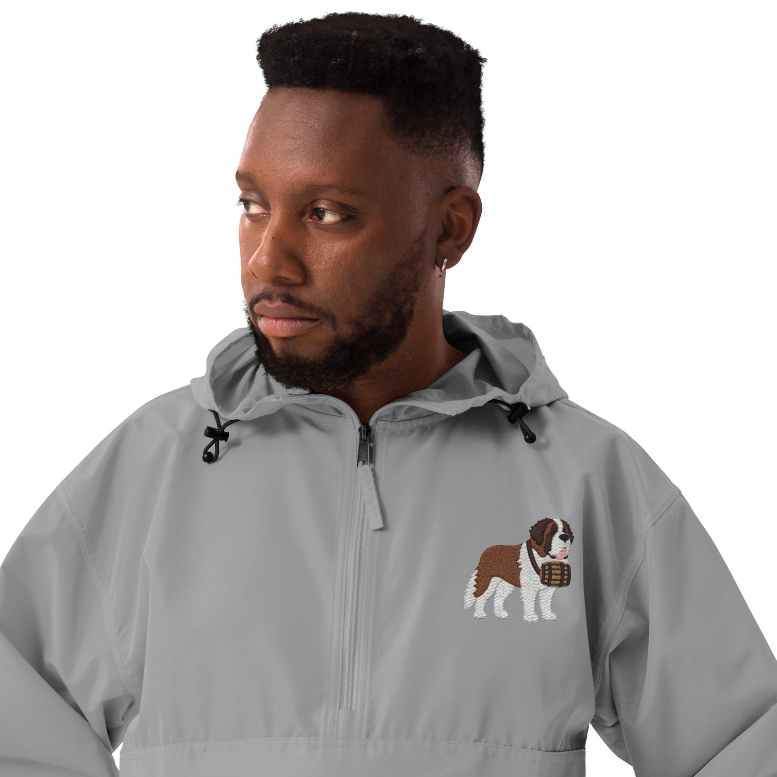 Light gray Champion packable windbreaker with chest embroidered Saint Bernard and barrel, half zip pullover with hood, kangaroo pocket, and zip pouch.