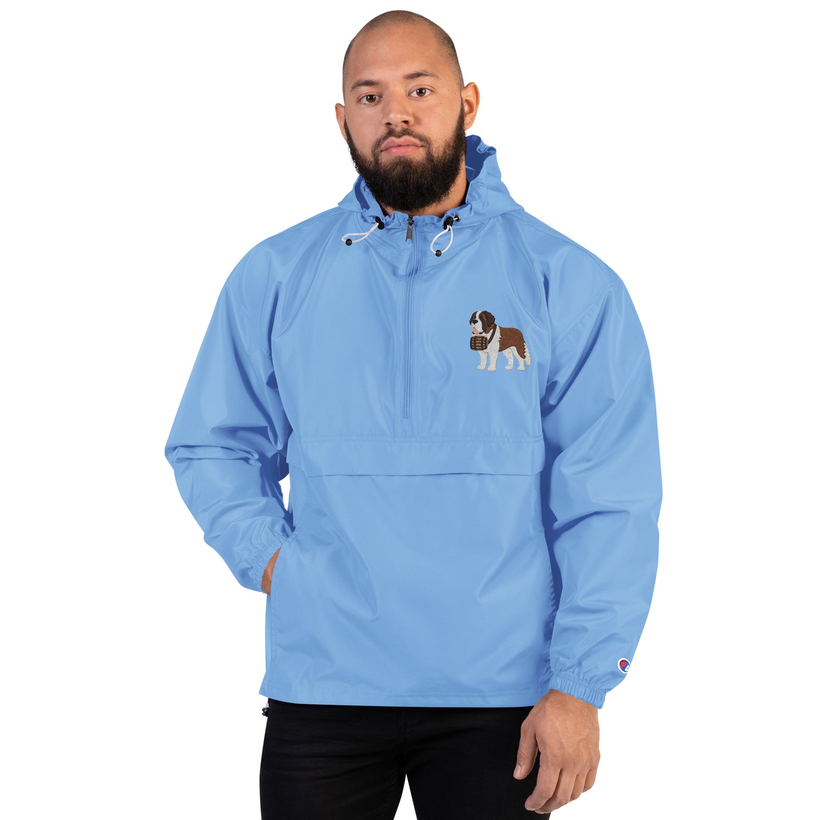 Light blue Champion packable windbreaker with chest embroidered Saint Bernard and barrel, half zip pullover with hood, kangaroo pocket, and zip pouch.
