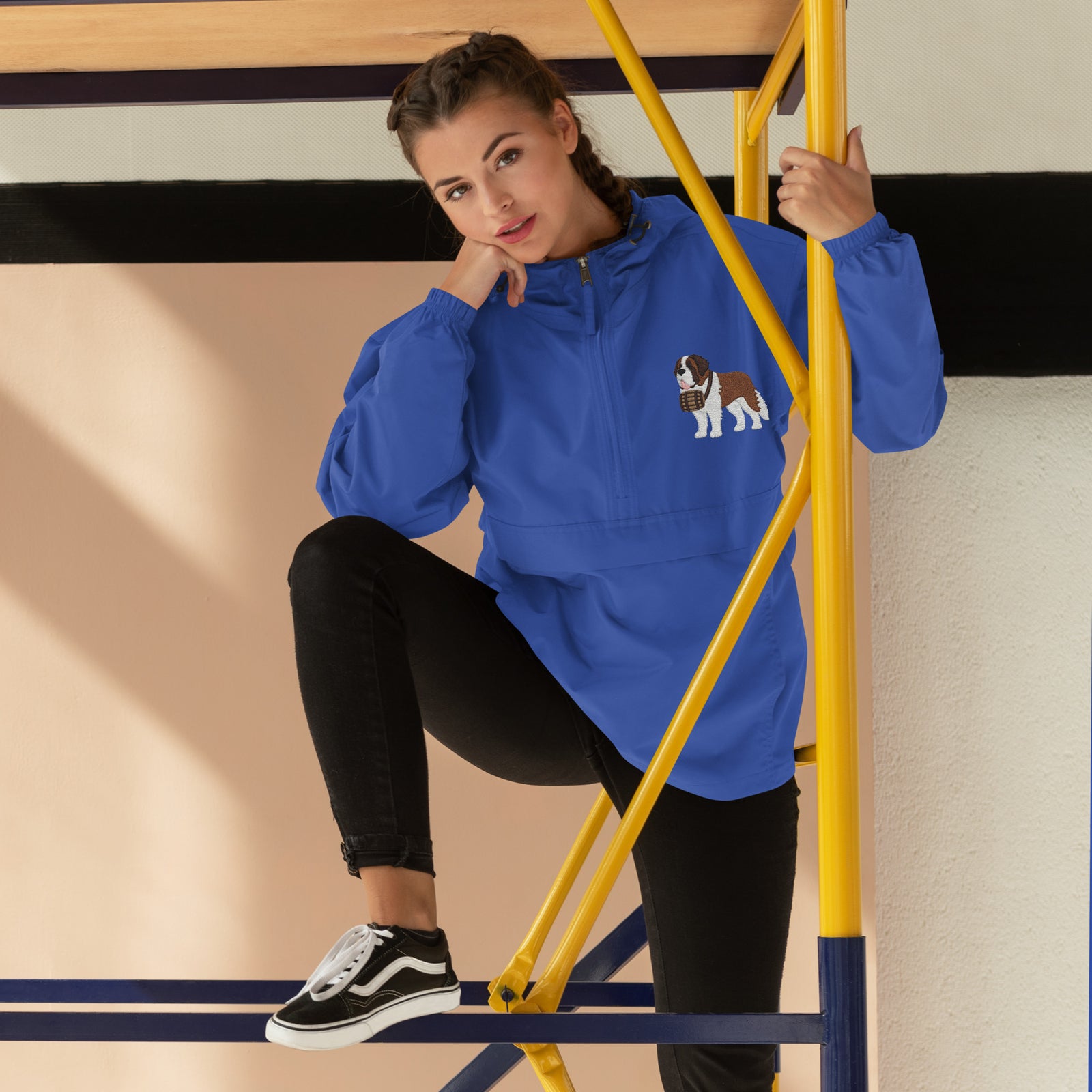 Royal blue Champion packable windbreaker with chest embroidered Saint Bernard and barrel, half zip pullover with hood, kangaroo pocket, and zip pouch.