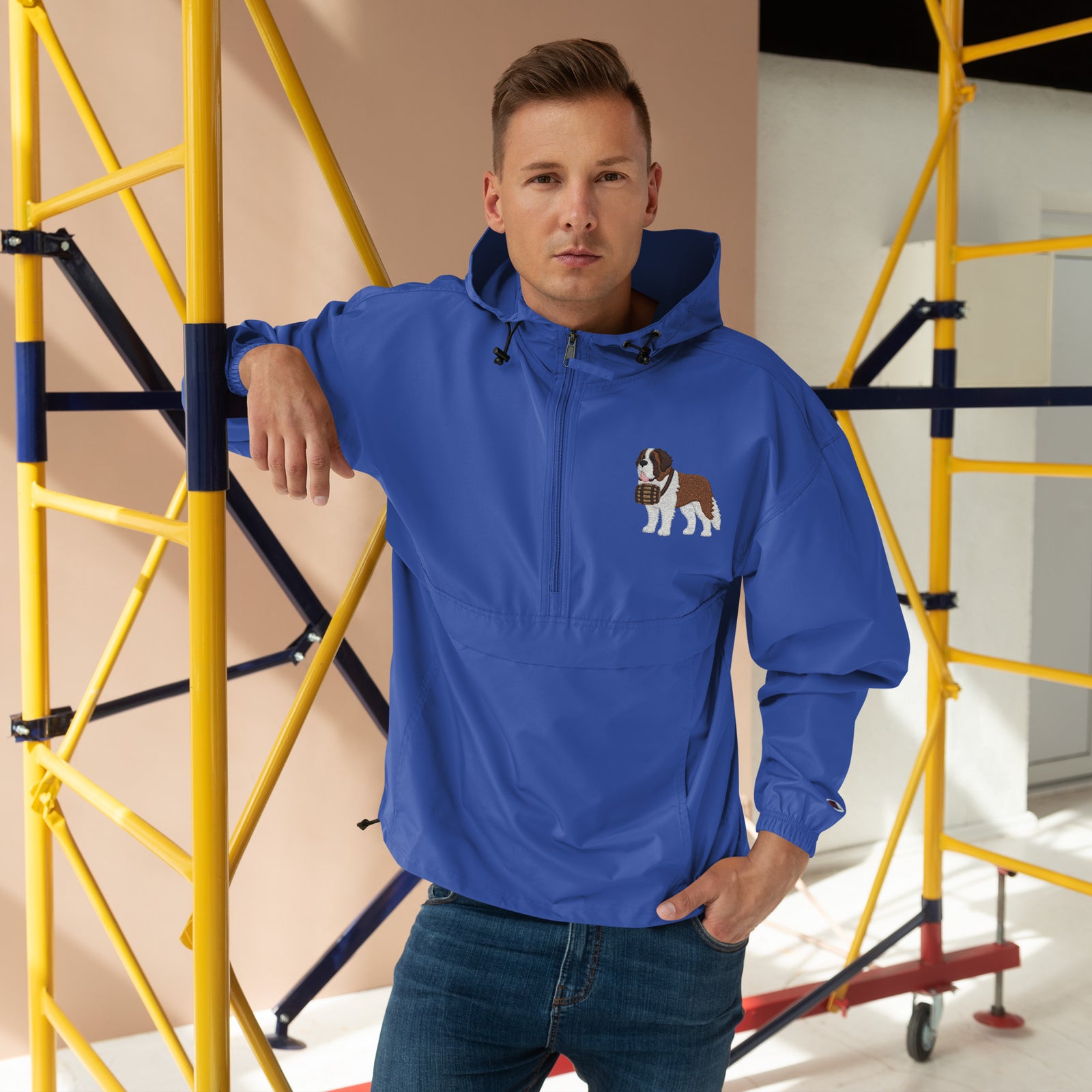 Royal blue Champion packable windbreaker with chest embroidered Saint Bernard and barrel, half zip pullover with hood, kangaroo pocket, and zip pouch.