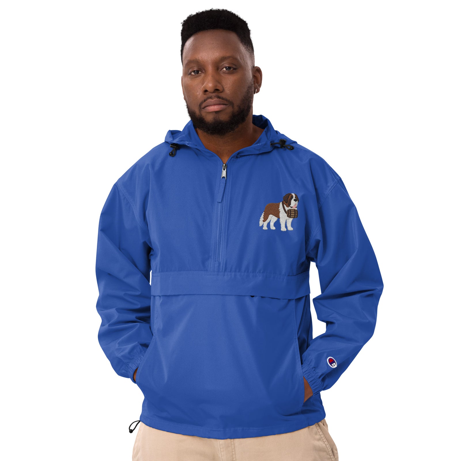 Royal blue Champion packable windbreaker with chest embroidered Saint Bernard and barrel, half zip pullover with hood, kangaroo pocket, and zip pouch.