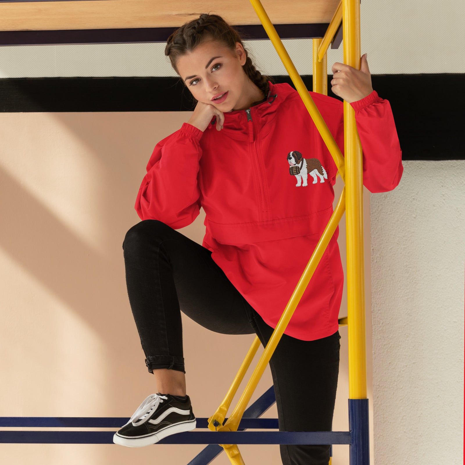 Red Champion packable windbreaker with chest embroidered Saint Bernard and barrel, half zip pullover with hood, kangaroo pocket, and zip pouch.