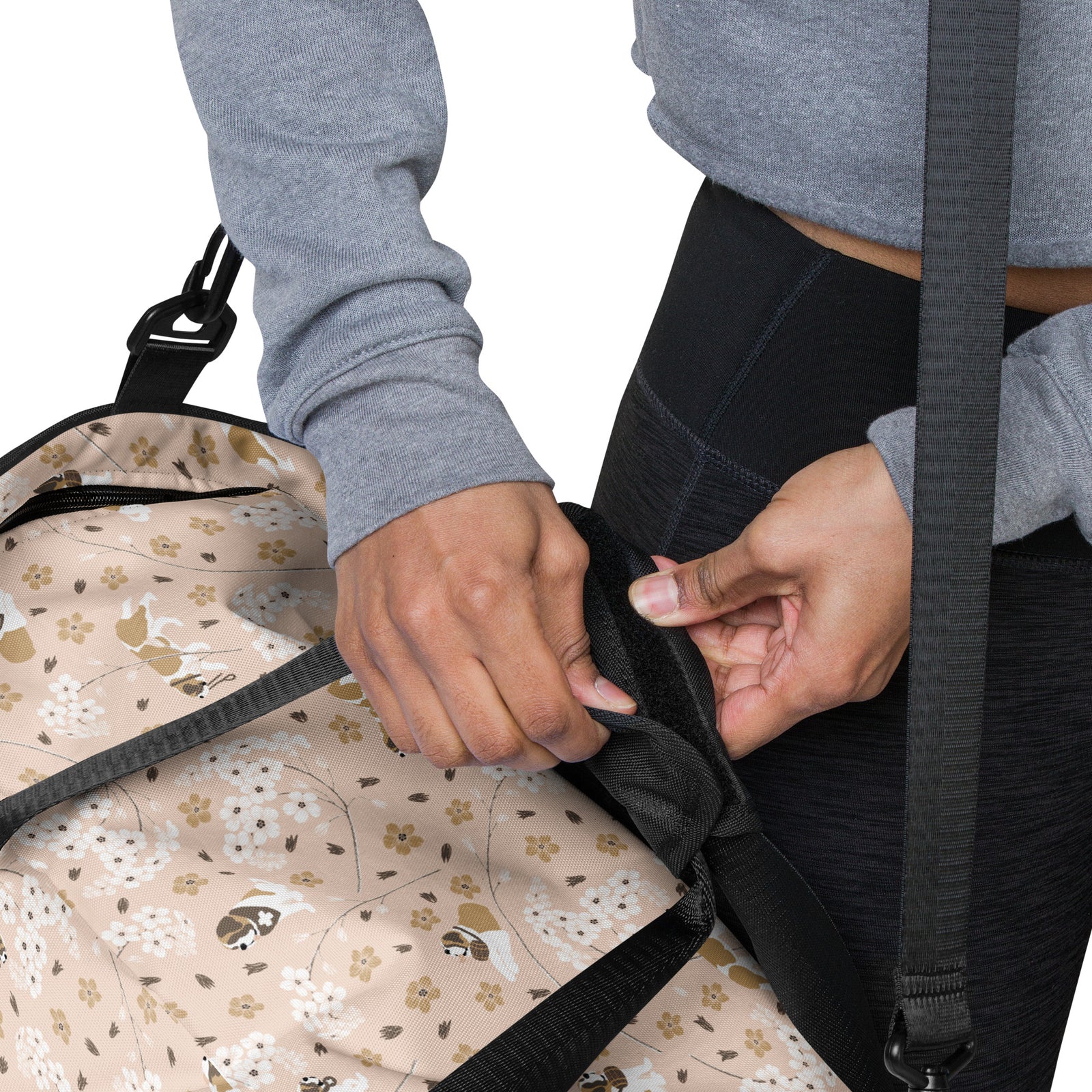 Floral Saint Bernard duffle bag with adjustable padded black shoulder strap, dual carry handles, zippered compartments, and mesh side pocket in white, brown, gold, and soft pink.