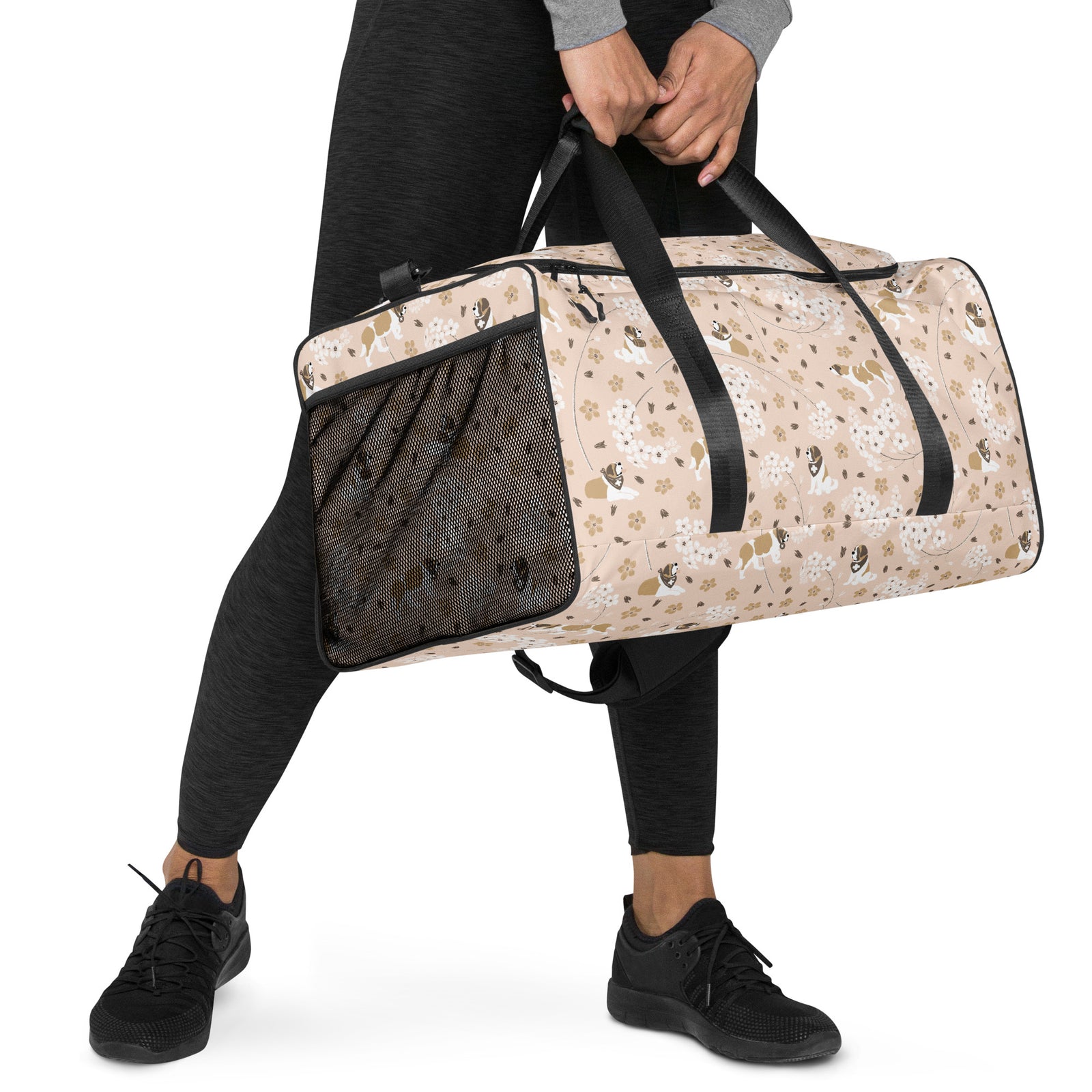 Floral Saint Bernard duffle bag with adjustable padded black shoulder strap, dual carry handles, zippered compartments, and mesh side pocket in white, brown, gold, and soft pink.