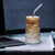 16 oz can-shaped glass tumbler, bamboo wood lid and metal straw. Features a modern pattern of Saint Bernard dogs, mountains and pine trees by Lucy and Norman