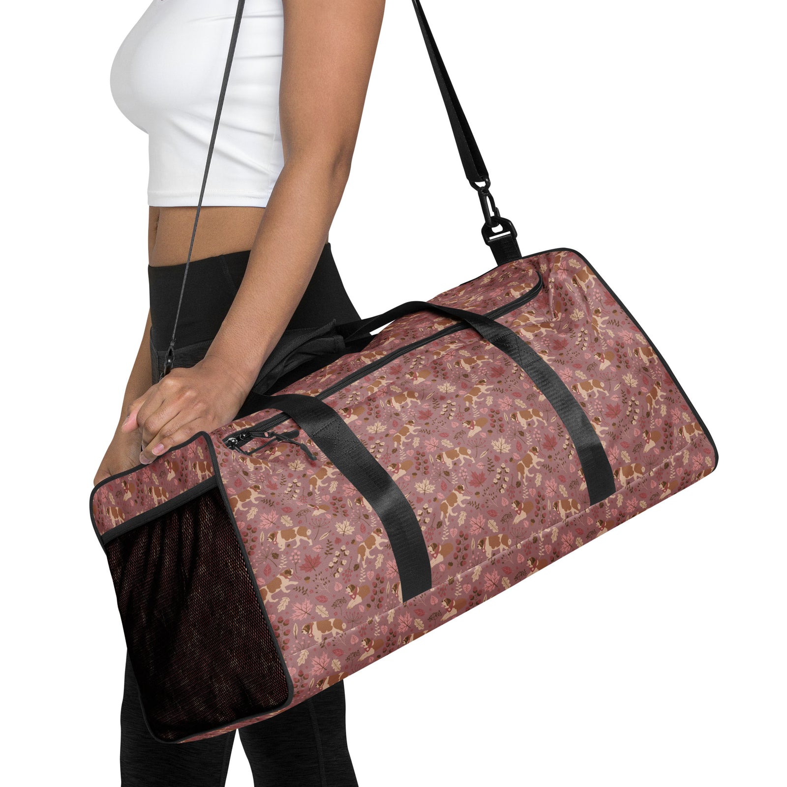 Rosy Fall Saint Bernard floral duffle bag in warm pink, brown, and autumn leaf tones with black padded shoulder strap, handles, zip compartment, and mesh side pocket.