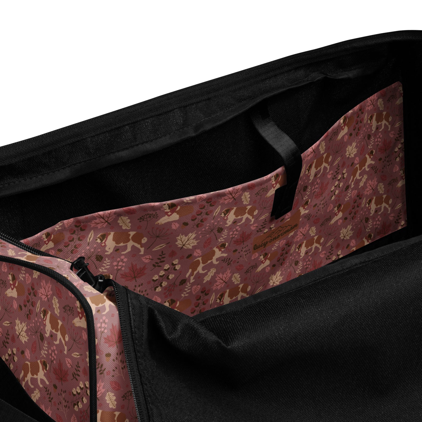 Rosy Fall Saint Bernard floral duffle bag in warm pink, brown, and autumn leaf tones with black padded shoulder strap, handles, zip compartment, and mesh side pocket.