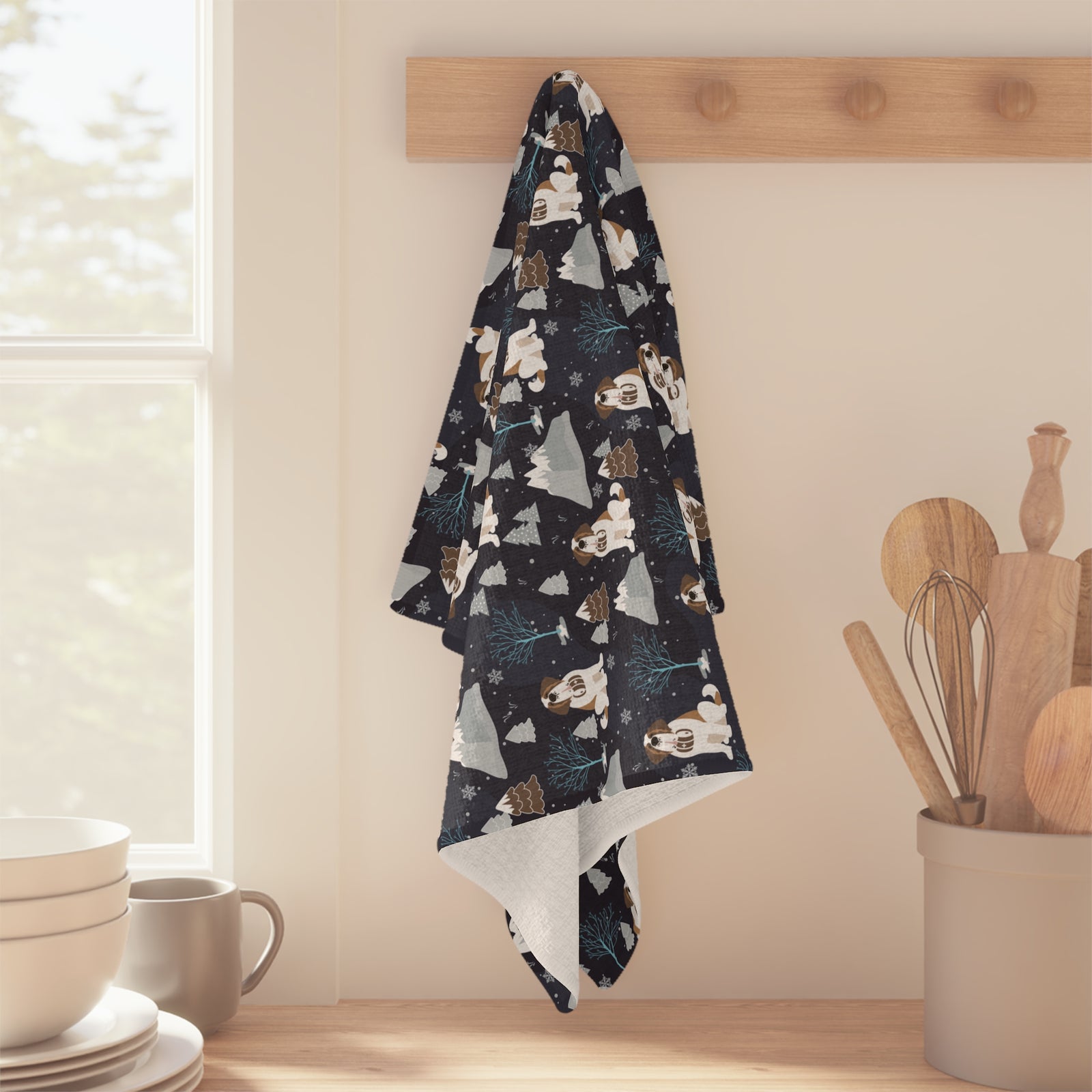 Alpine Chill Saint Bernard microfiber tea towel with a navy print of Saint Bernards with rescue barrels among frosty trees and snowy mountains.