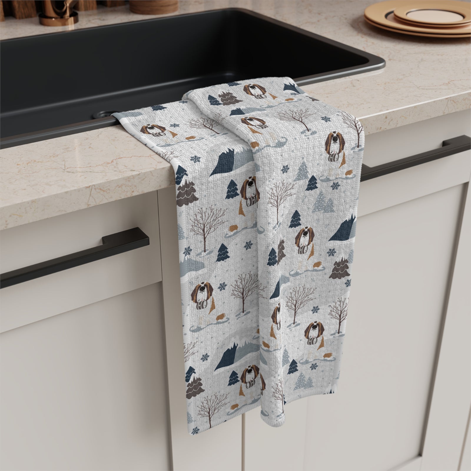 Saint Bernard Alpine microfiber tea towel with a soft gray and white print of Saint Bernards, snowy mountains, and pine trees, draped over a kitchen counter.