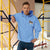 Light blue Champion packable windbreaker with chest embroidered Saint Bernard and barrel, half zip pullover with hood, kangaroo pocket, and zip pouch.