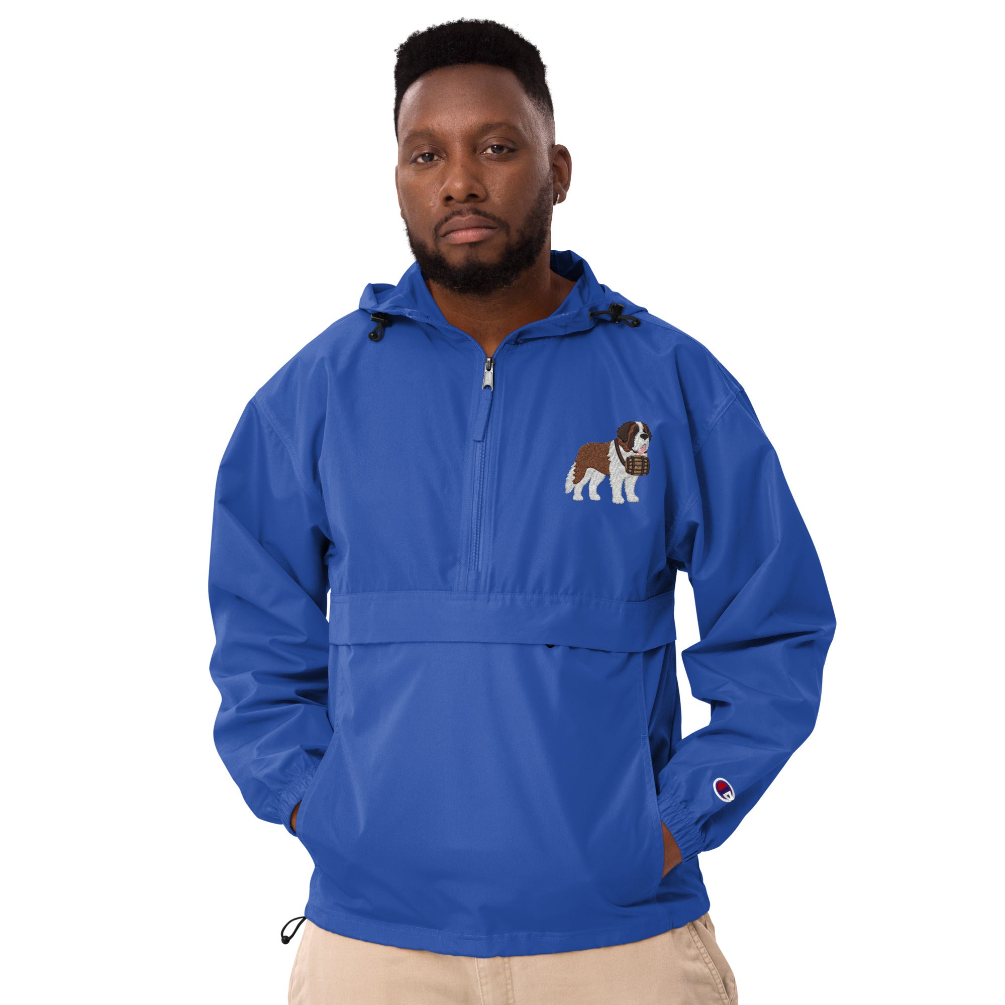 Royal blue Champion packable windbreaker with chest embroidered Saint Bernard and barrel, half zip pullover with hood, kangaroo pocket, and zip pouch.