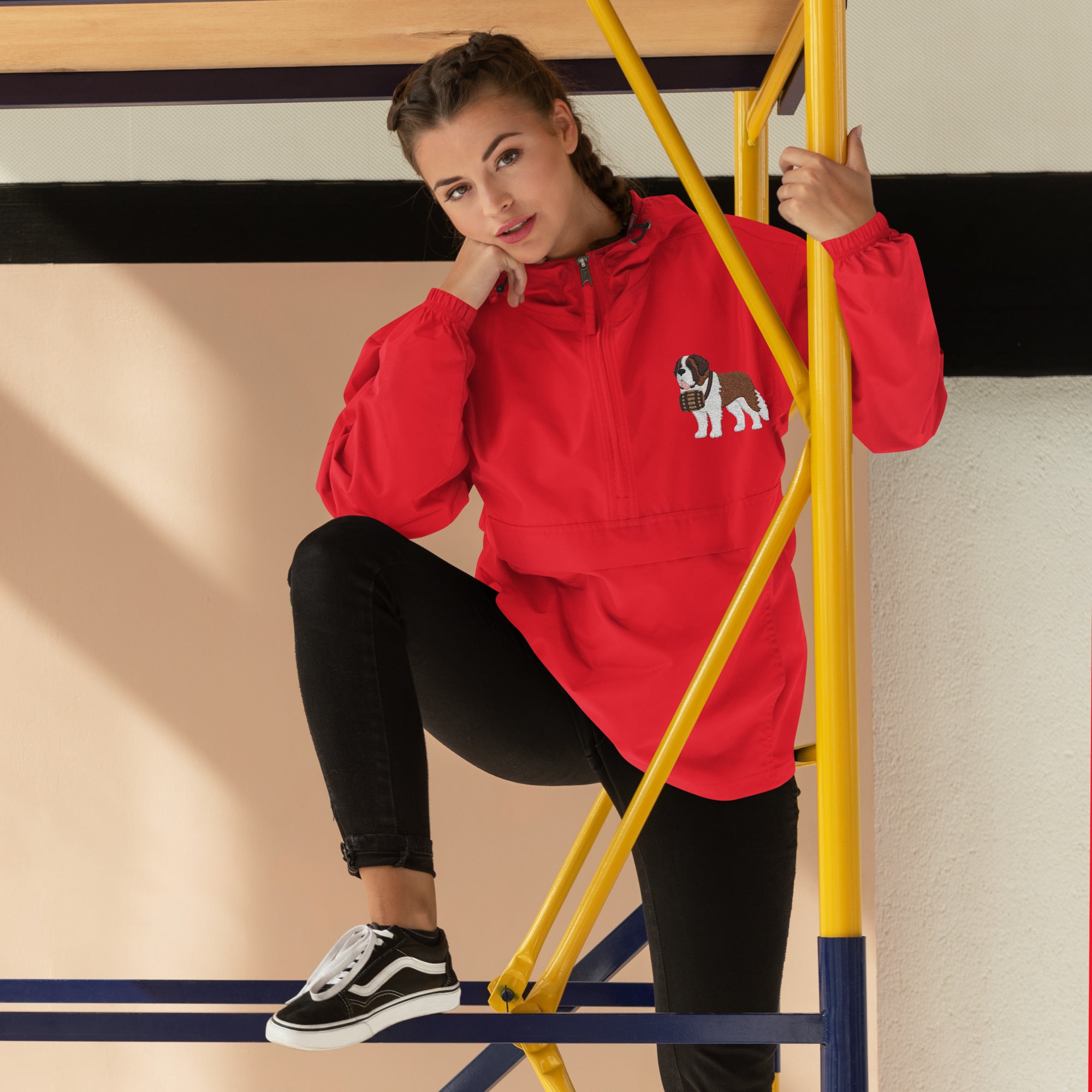 Red Champion packable windbreaker with chest embroidered Saint Bernard and barrel, half zip pullover with hood, kangaroo pocket, and zip pouch.