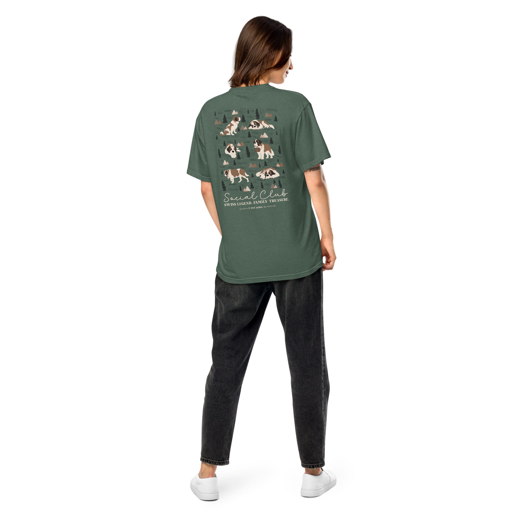 Comfort Colors blue spruce t-shirt featuring a woodland-mountain theme with Saint Bernard dogs on the back with a badge on left chest. Perfect Saint Bernard gift for dog lovers.