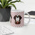 White ceramic mug featuring a cute illustrated Saint Bernard dog wearing a rescue barrel, surrounded by a red Swiss cross pattern. Perfect gift for St Bernard dog lovers and Swiss Alps fans by Lucy and Norman.