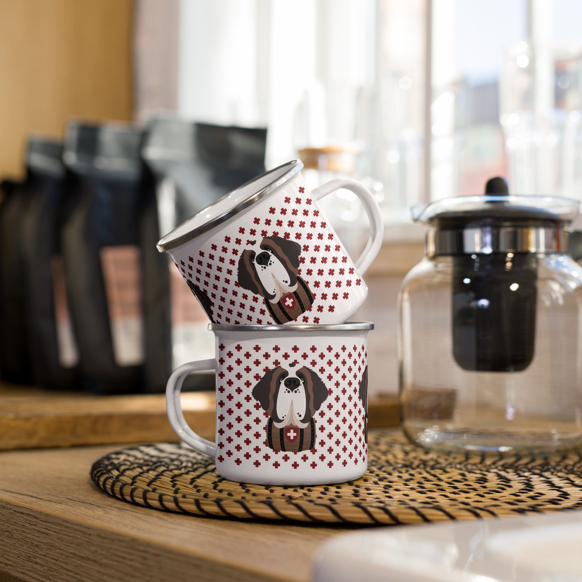 White enamel 12 ounce camp mug with silver rim featuring a cute illustrated Saint Bernard dog wearing a rescue barrel, surrounded by a red Swiss cross pattern. Perfect gift for St Bernard dog lovers and Swiss Alps fans by Lucy and Norman.