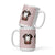 White ceramic 15 ounce mug featuring a cute illustrated Saint Bernard dog wearing a rescue barrel, surrounded by a red Swiss cross pattern. Perfect gift for St Bernard dog lovers and Swiss Alps fans by Lucy and Norman.