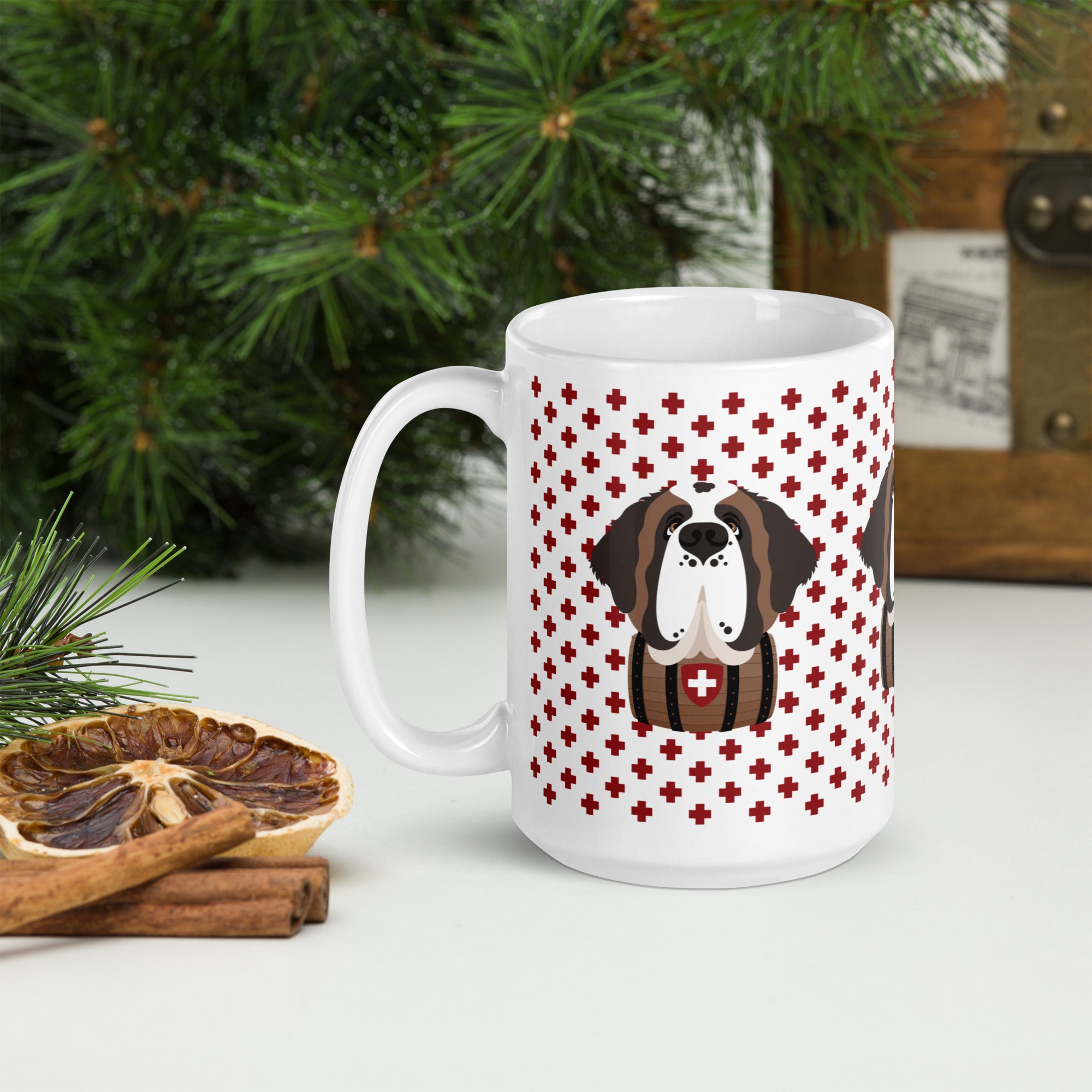 White ceramic 15 ounce mug featuring a cute illustrated Saint Bernard dog wearing a rescue barrel, surrounded by a red Swiss cross pattern. Perfect gift for St Bernard dog lovers and Swiss Alps fans by Lucy and Norman.