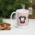 White ceramic 15 ounce mug featuring a cute illustrated Saint Bernard dog wearing a rescue barrel, surrounded by a red Swiss cross pattern. Perfect gift for St Bernard dog lovers and Swiss Alps fans by Lucy and Norman.