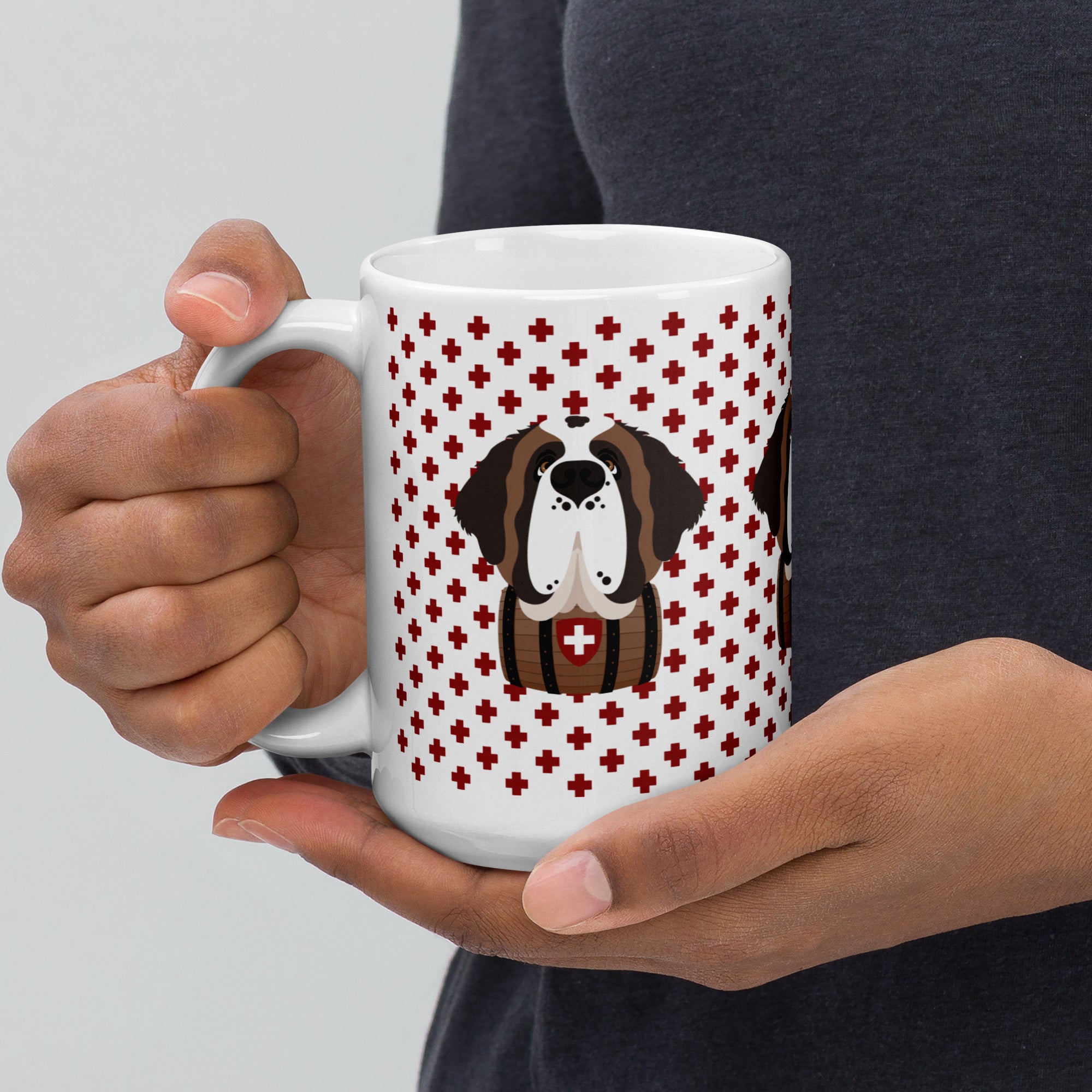 White ceramic 15 ounce mug featuring a cute illustrated Saint Bernard dog wearing a rescue barrel, surrounded by a red Swiss cross pattern. Perfect gift for St Bernard dog lovers and Swiss Alps fans by Lucy and Norman.