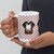 White ceramic 15 ounce mug featuring a cute illustrated Saint Bernard dog wearing a rescue barrel, surrounded by a red Swiss cross pattern. Perfect gift for St Bernard dog lovers and Swiss Alps fans by Lucy and Norman.