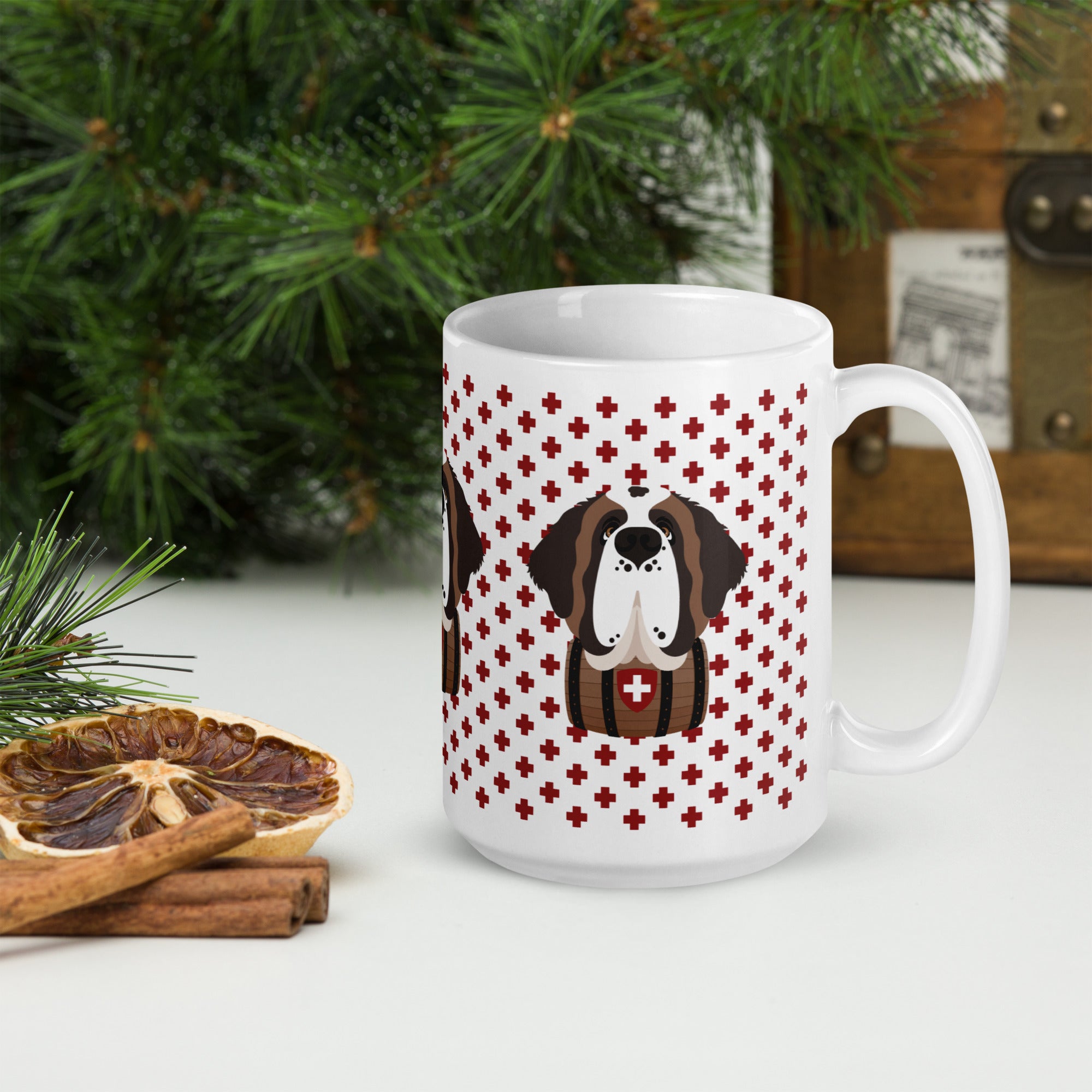 White ceramic 15 ounce mug featuring a cute illustrated Saint Bernard dog wearing a rescue barrel, surrounded by a red Swiss cross pattern. Perfect gift for St Bernard dog lovers and Swiss Alps fans by Lucy and Norman.